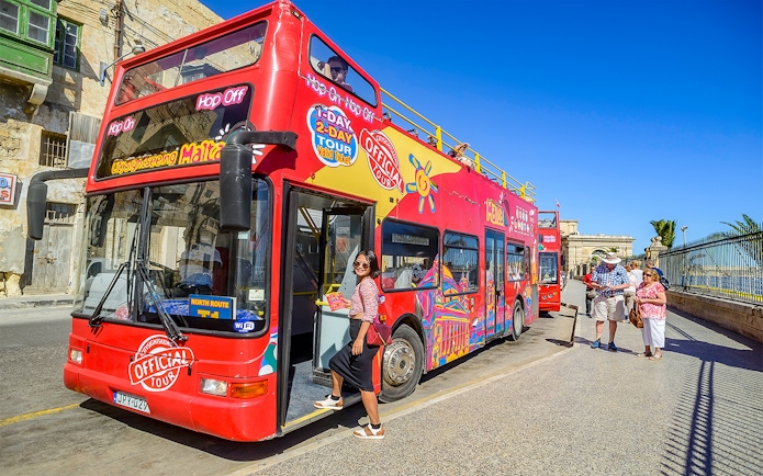 Red double-decker bus for Malta Hop-On-Hop-Off Tour with passengers boarding.