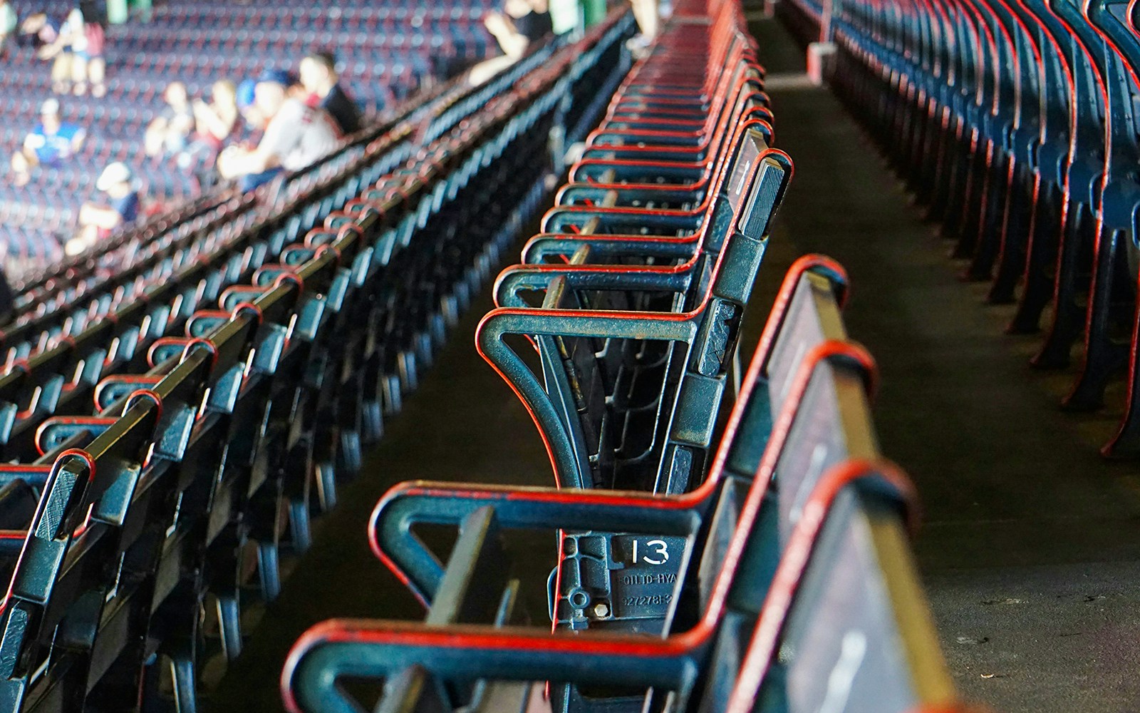 Fenway Park seating rows with fans in the background, Boston.