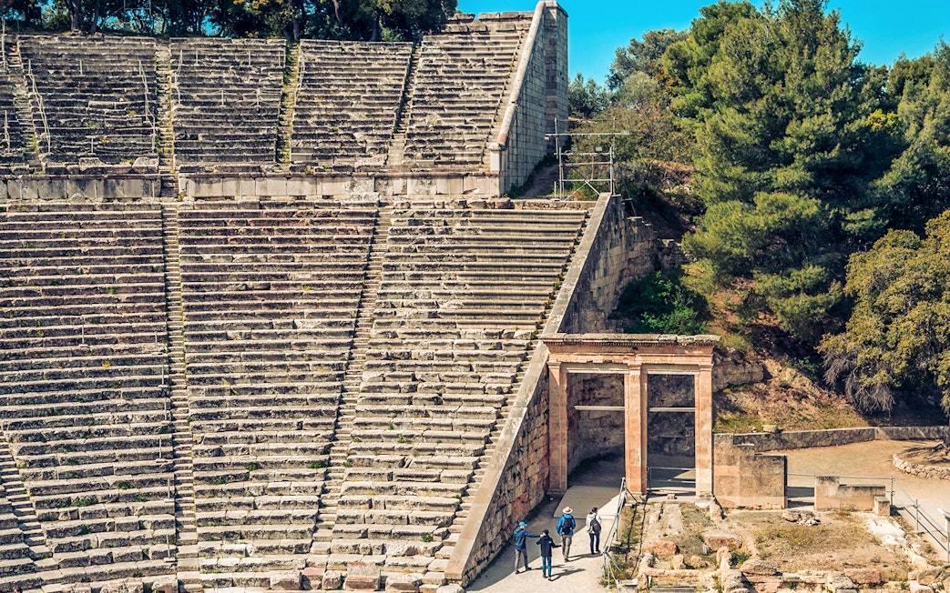 Epidaurus Ancient Theatre stone seating and entrance with visitors exploring.