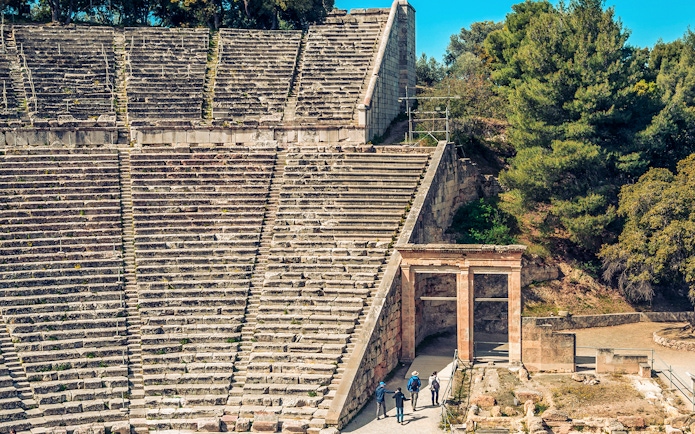 Epidaurus Ancient Theatre stone seating and entrance with visitors exploring.