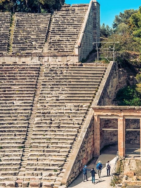 Epidaurus Ancient Theatre stone seating and entrance with visitors exploring.