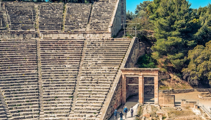 Epidaurus Ancient Theatre stone seating and entrance with visitors exploring.