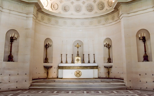 Expiatory Chapel altar with ornate candlesticks and crucifix in Paris, France.