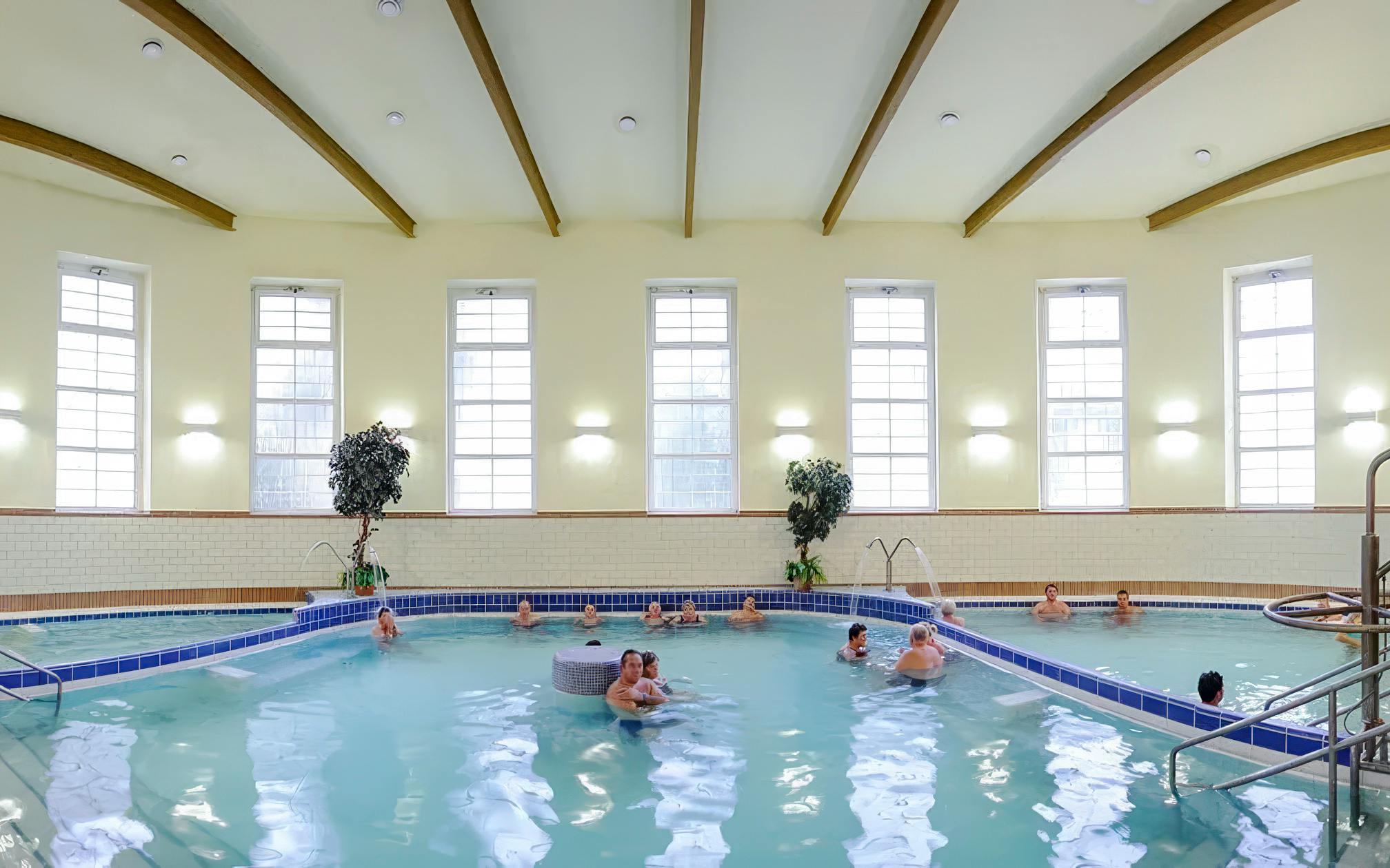 Indoor pool at Dandar Spa with people relaxing in the water.