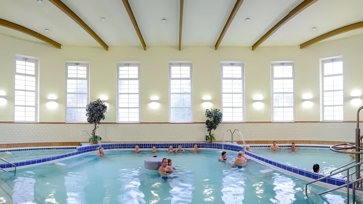 Indoor pool at Dandar Spa with people relaxing in the water.