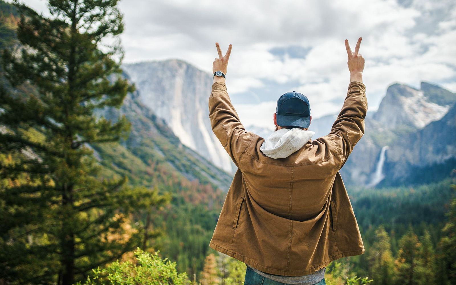 Visitor enjoying the view of El Capitan and Bridalveil Fall at Yosemite National Park, California.