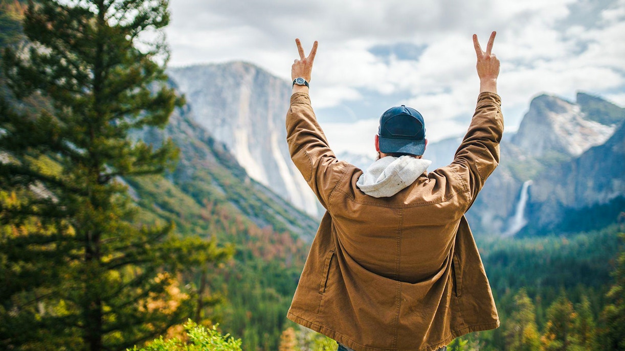 Visitor enjoying the view of El Capitan and Bridalveil Fall at Yosemite National Park, California.