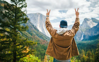 Visitor enjoying the view of El Capitan and Bridalveil Fall at Yosemite National Park, California.