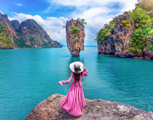 Woman in pink dress on rock at James Bond Island, Phang Nga, Thailand.