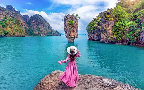Woman in pink dress on rock at James Bond Island, Phang Nga, Thailand.