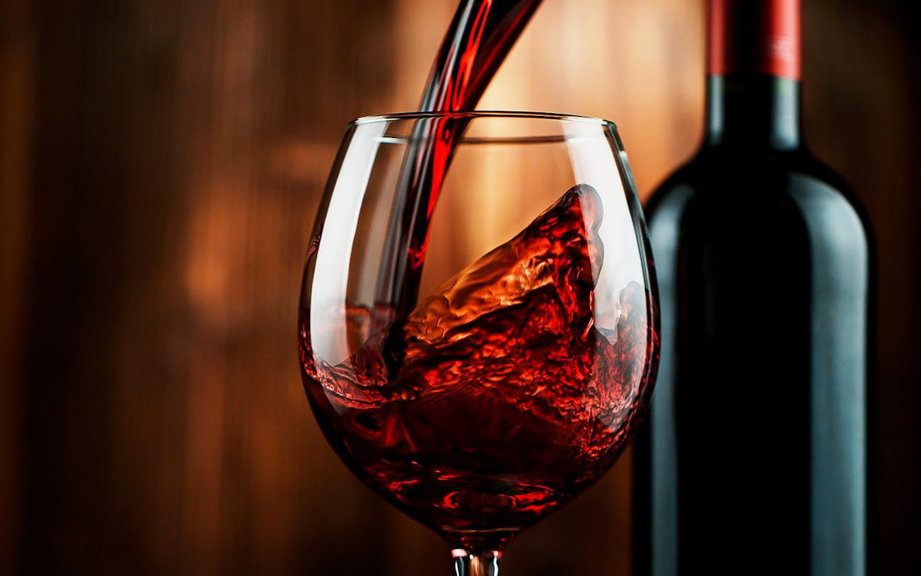 Pouring red wine into a glass at Argiolas Winery, Serdiana.