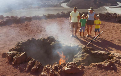 Family observing geothermal demonstration at Timanfaya National Park, Lanzarote.