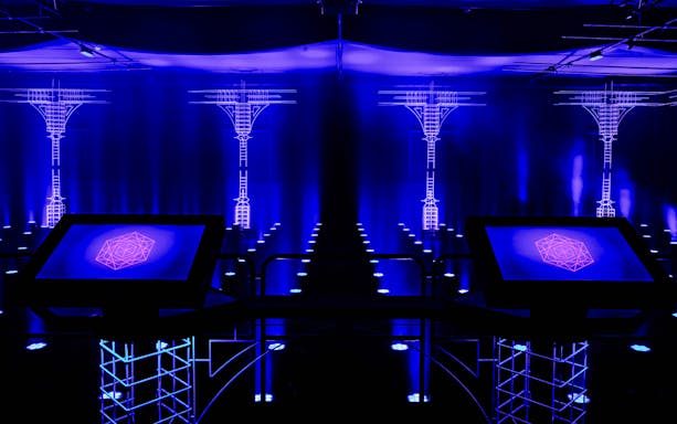 Interactive digital art installation at AMAZE Amsterdam with neon blue lighting.