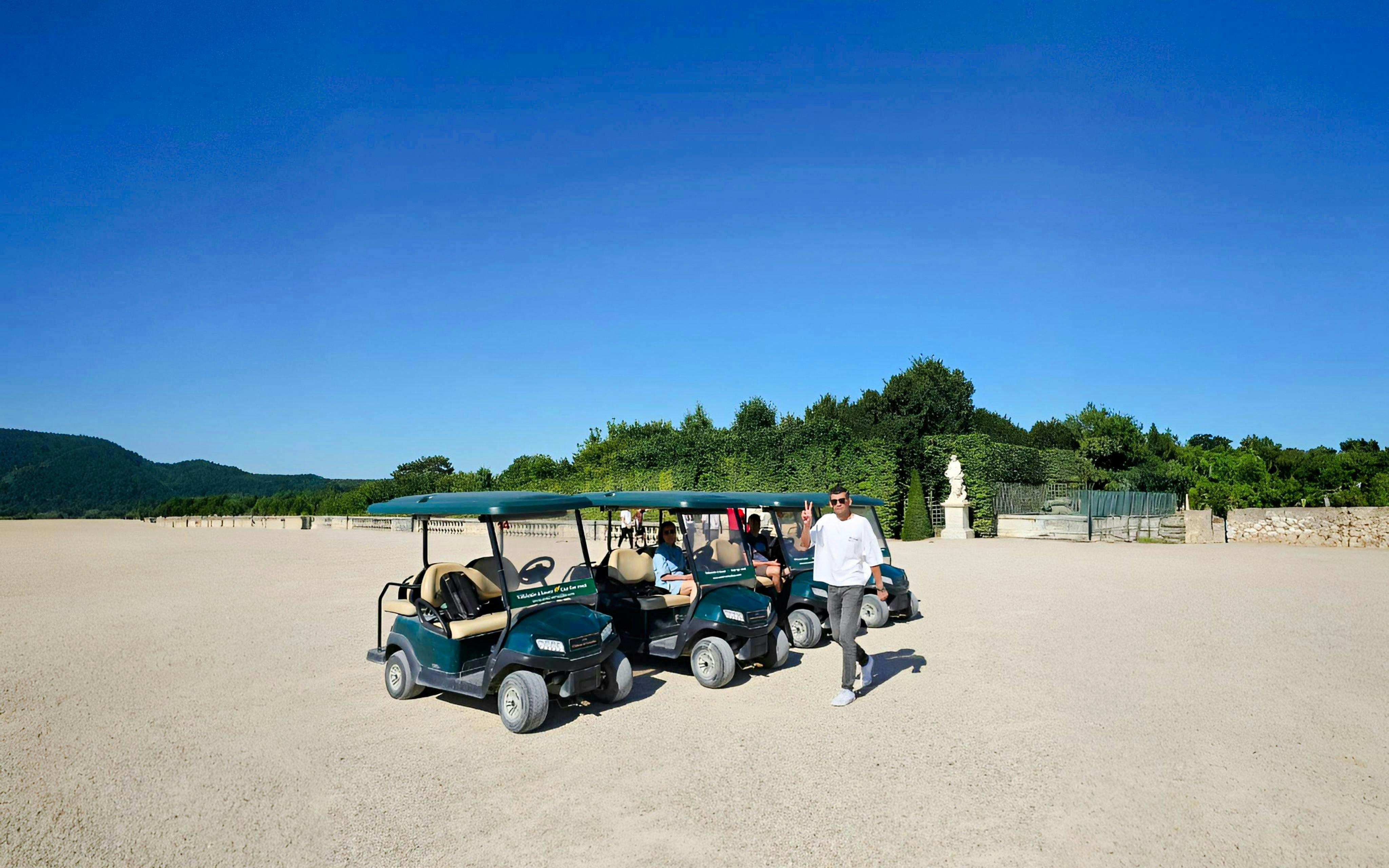 Golf carts parked in Versailles Gardens during guided tour.