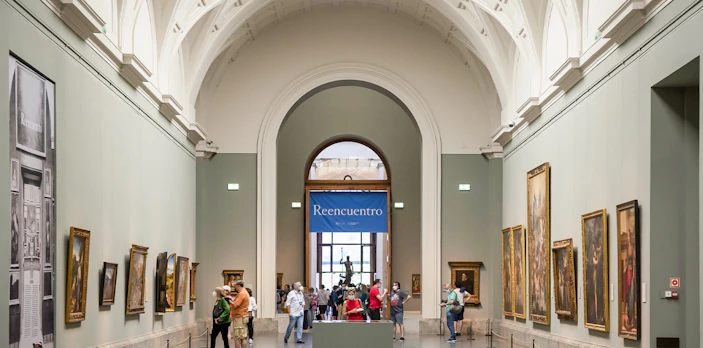 Visitors viewing paintings in a gallery at the Prado Museum, Madrid.
