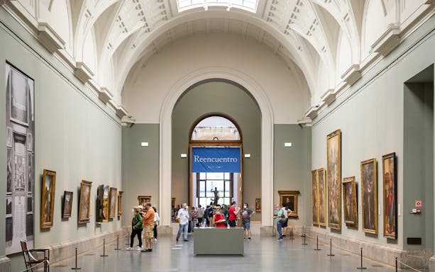 Visitors viewing paintings in a gallery at the Prado Museum, Madrid.