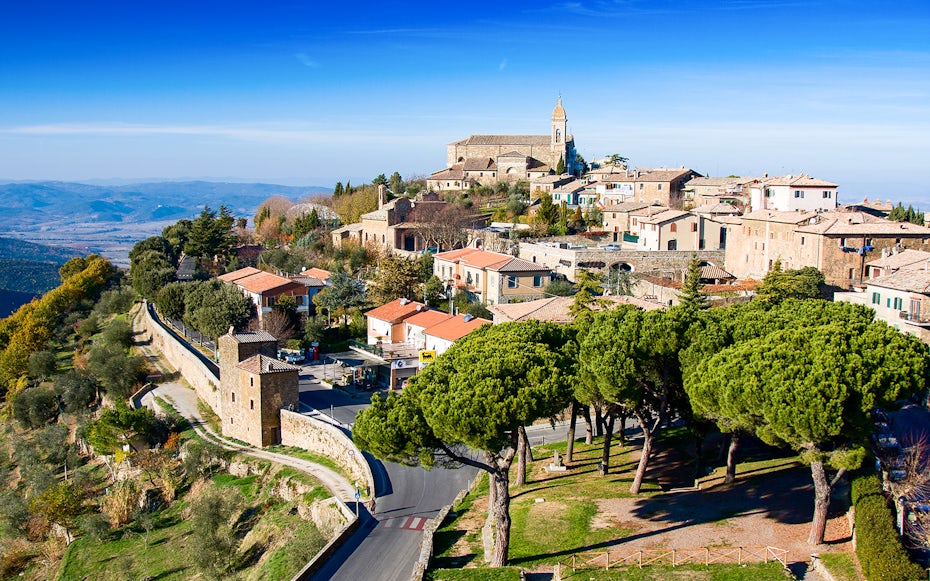 Hilltop view of Montalcino, Italy, featuring historic buildings and scenic landscape.