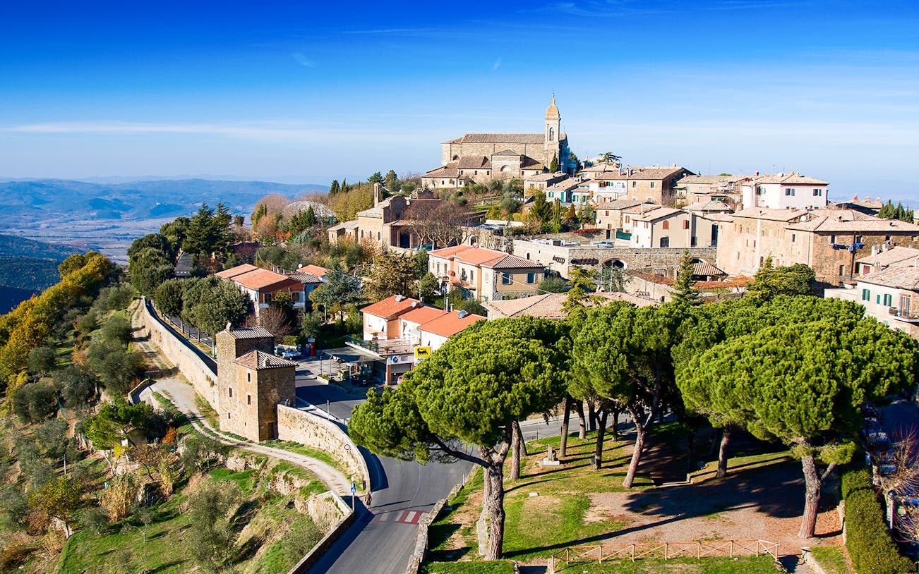 Hilltop view of Montalcino, Italy, featuring historic buildings and scenic landscape.