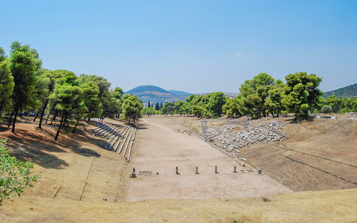 Ancient Olympia stadium with ruins and trees, Greece, viewed from Katakolo Port tour.