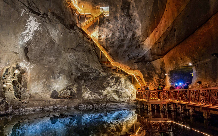 Visitors exploring the illuminated salt lake in the Wieliczka Salt Mine, Poland.