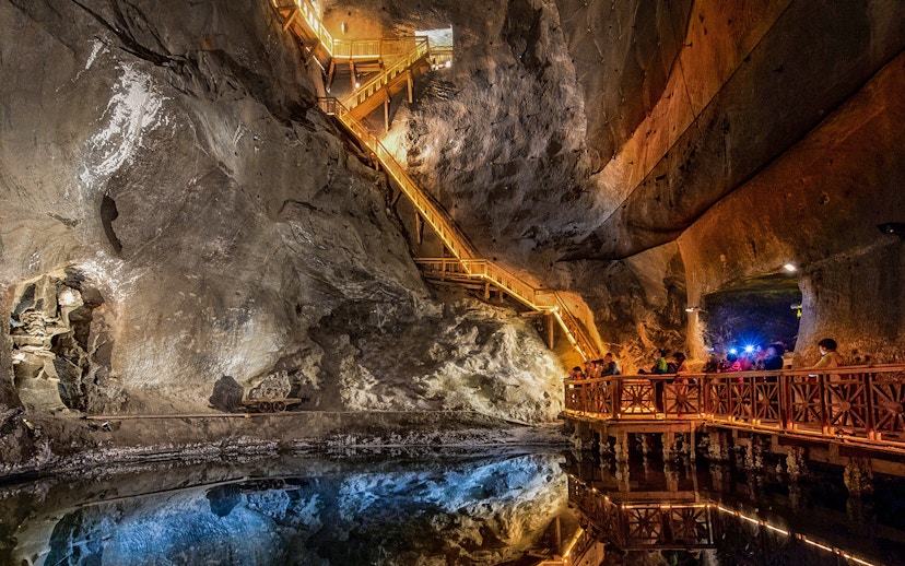 Visitors exploring the illuminated salt lake in the Wieliczka Salt Mine, Poland.