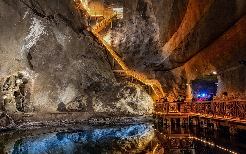 Visitors exploring the illuminated salt lake in the Wieliczka Salt Mine, Poland.