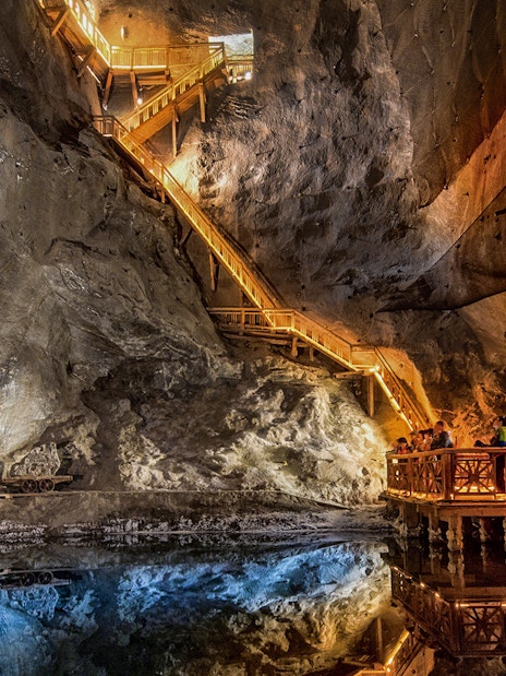 Visitors exploring the illuminated salt lake in the Wieliczka Salt Mine, Poland.