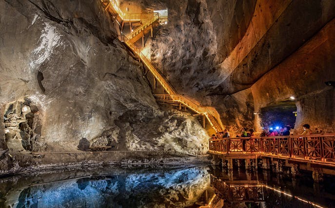 Visitors exploring the illuminated salt lake in the Wieliczka Salt Mine, Poland.