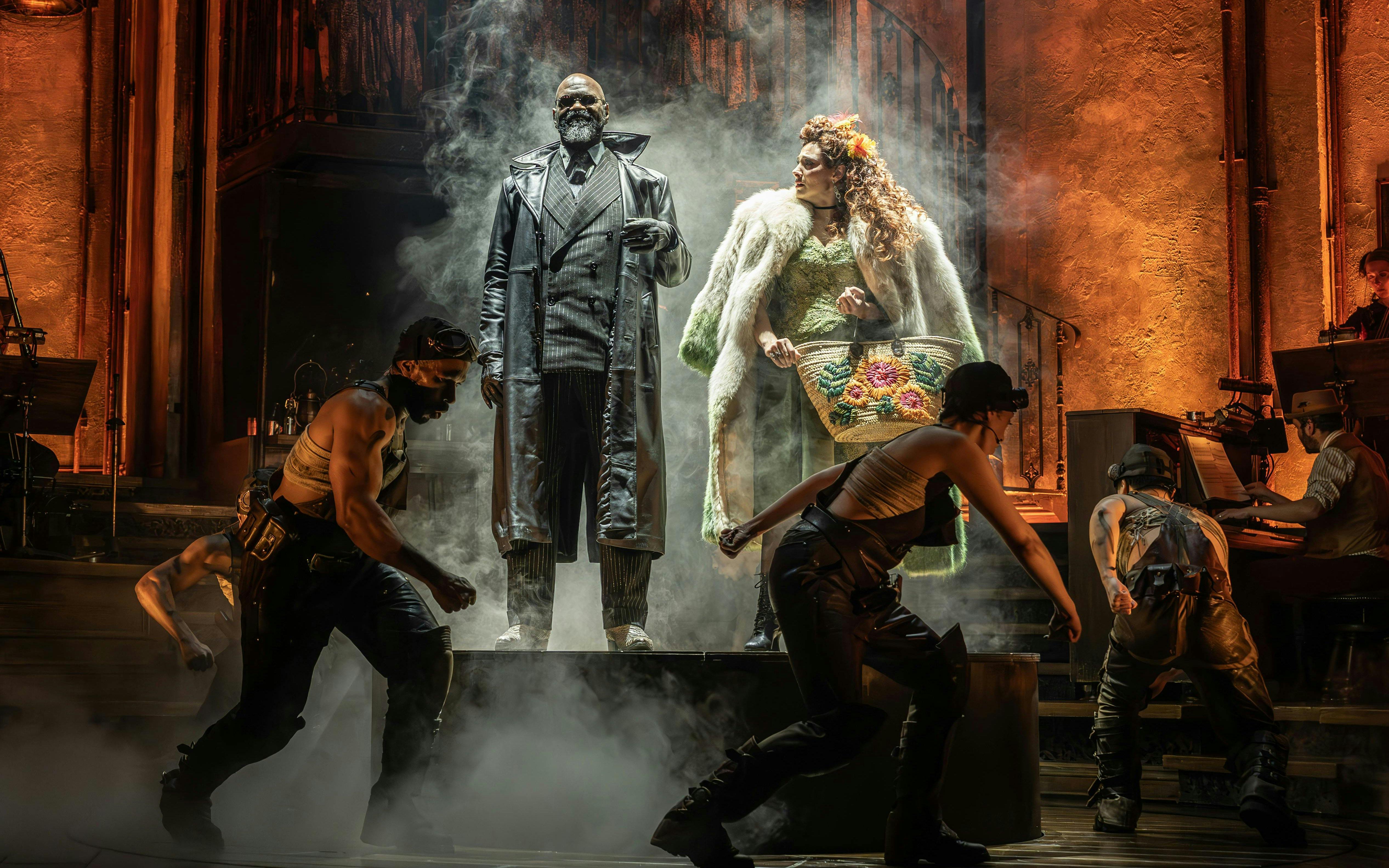 Stage performance of Hadestown in West End with actors in dramatic poses.