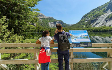 Visitors at a viewpoint near Puerto Blest, overlooking mountains and a lake.