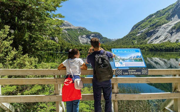 Visitors at a viewpoint near Puerto Blest, overlooking mountains and a lake.
