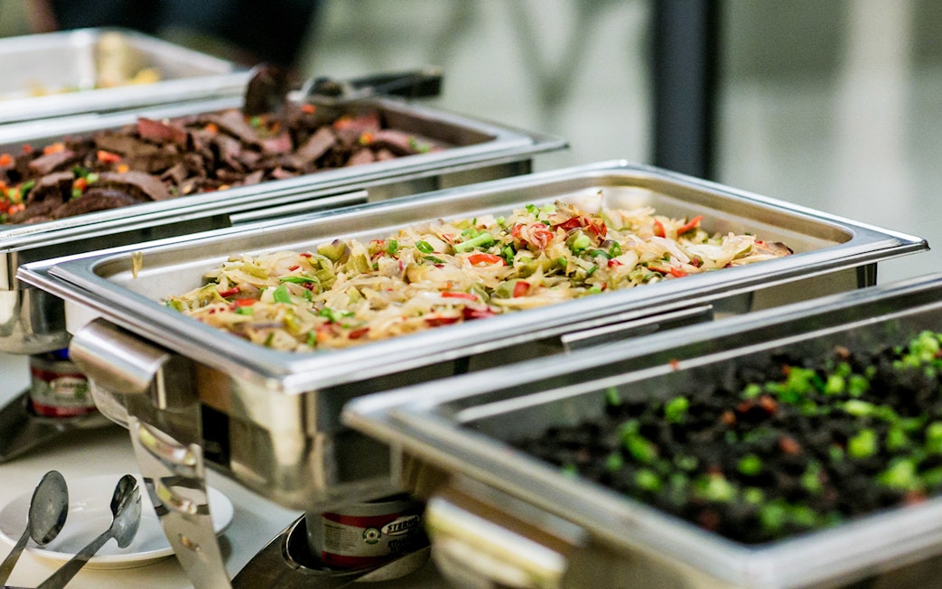 Buffet trays with assorted dishes for tour lunch.