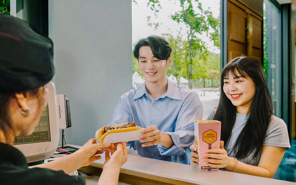 Happy couple receiving snacks at Gangchon Gimnyujeong Rail Bike experience.