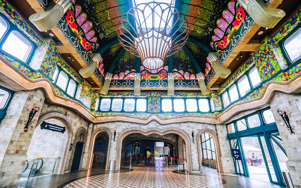 Colorful interior of Sun World Ba Den Mountain entrance hall with ornate ceiling and stained glass windows.