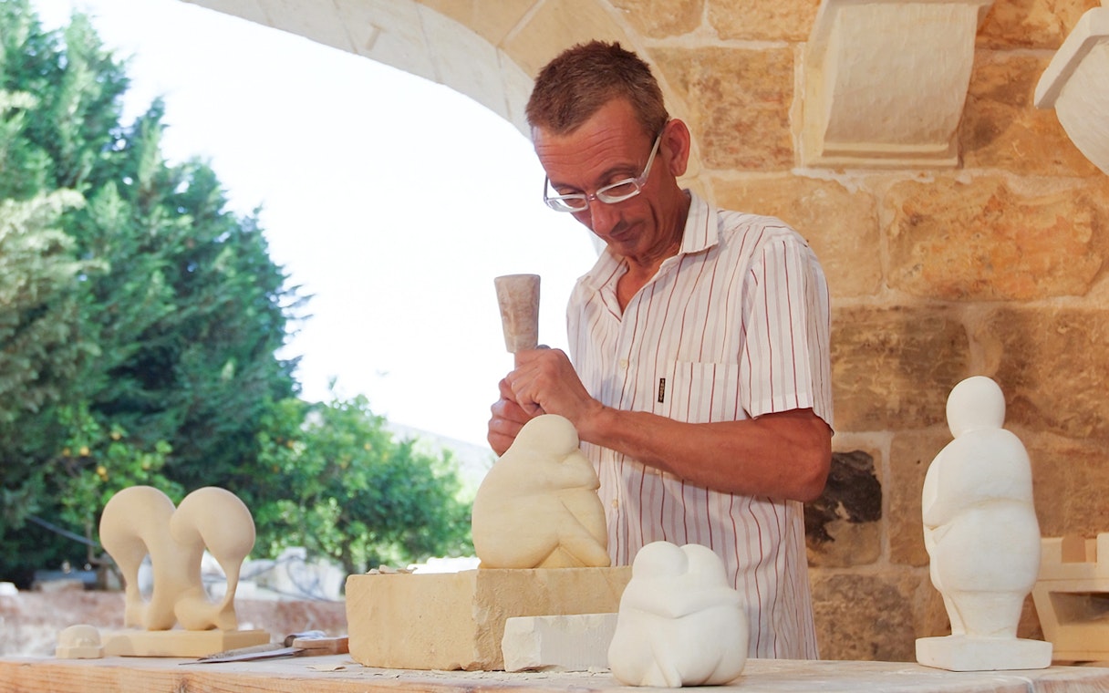 Sculptor carving limestone at The Limestone Heritage Park & Gardens, Malta.