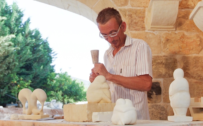 Sculptor carving limestone at The Limestone Heritage Park & Gardens, Malta.