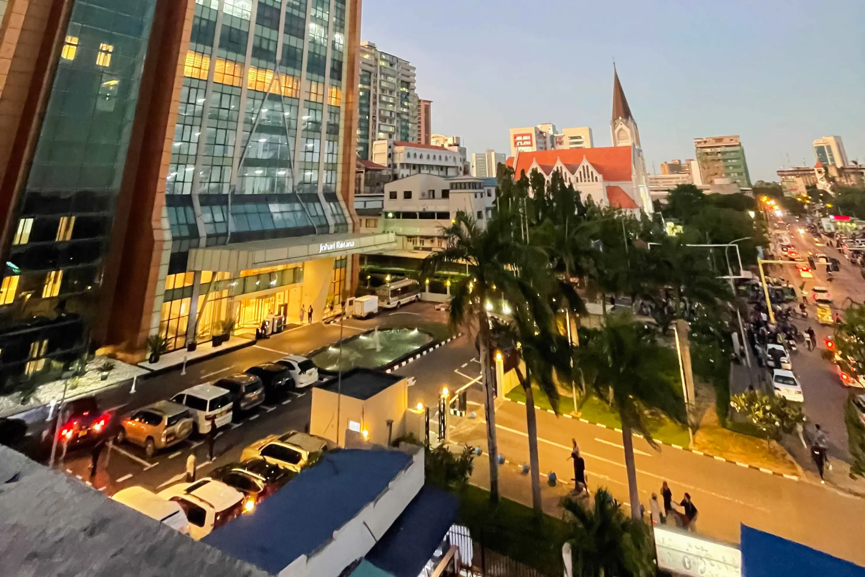 Evening view of a busy street in Zanzibar with modern buildings and a church.