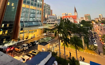 Evening view of a busy street in Zanzibar with modern buildings and a church.