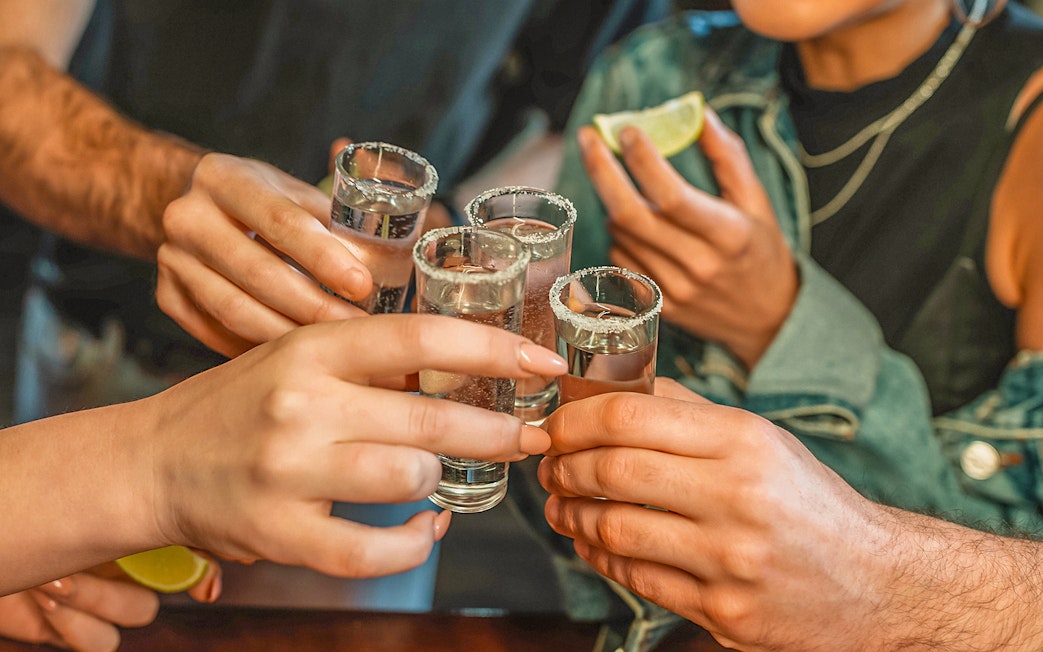 Friends toasting with shot glasses at a nightclub.