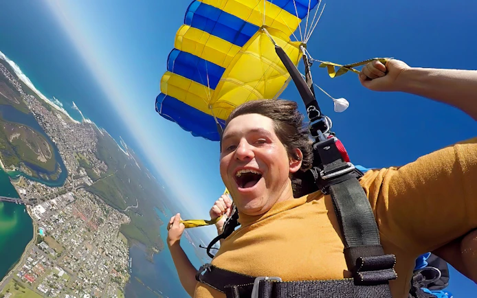 Tandem skydiver over Newcastle, Australia with parachute open.