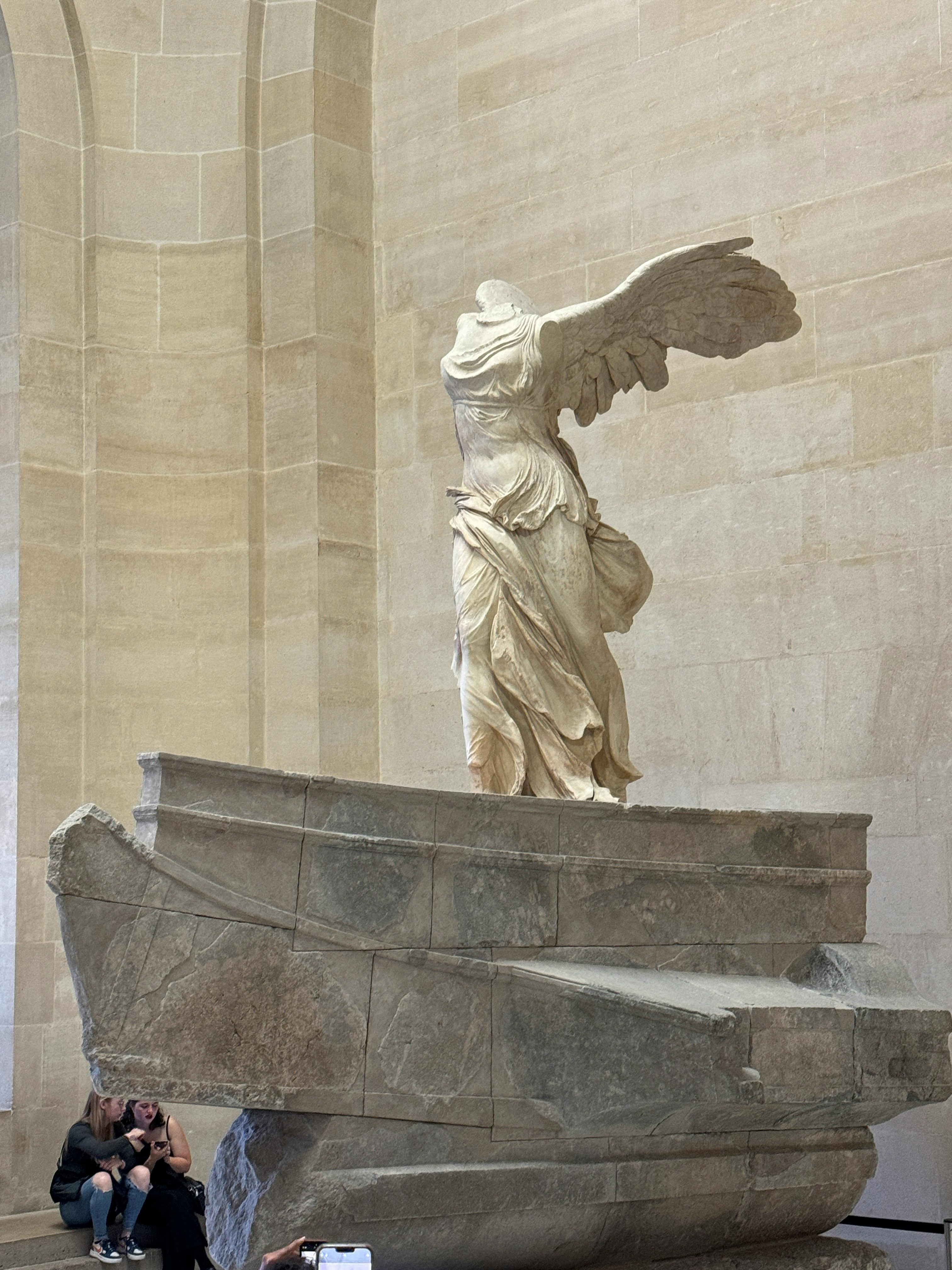 Winged Victory of Samothrace statue displayed at Louvre Museum, Paris, showcasing Hellenistic art.