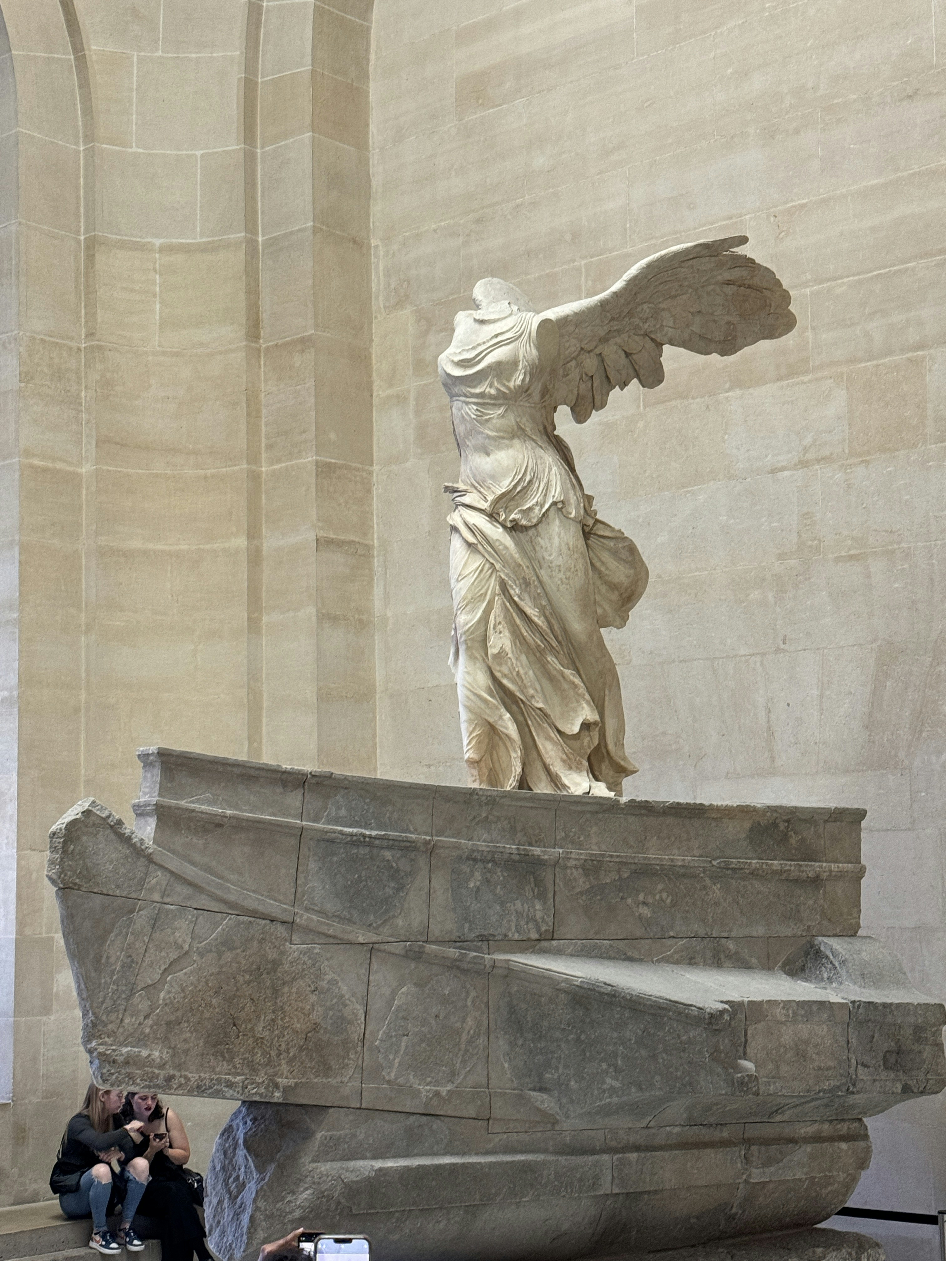 Winged Victory of Samothrace statue displayed at Louvre Museum, Paris, showcasing Hellenistic art.