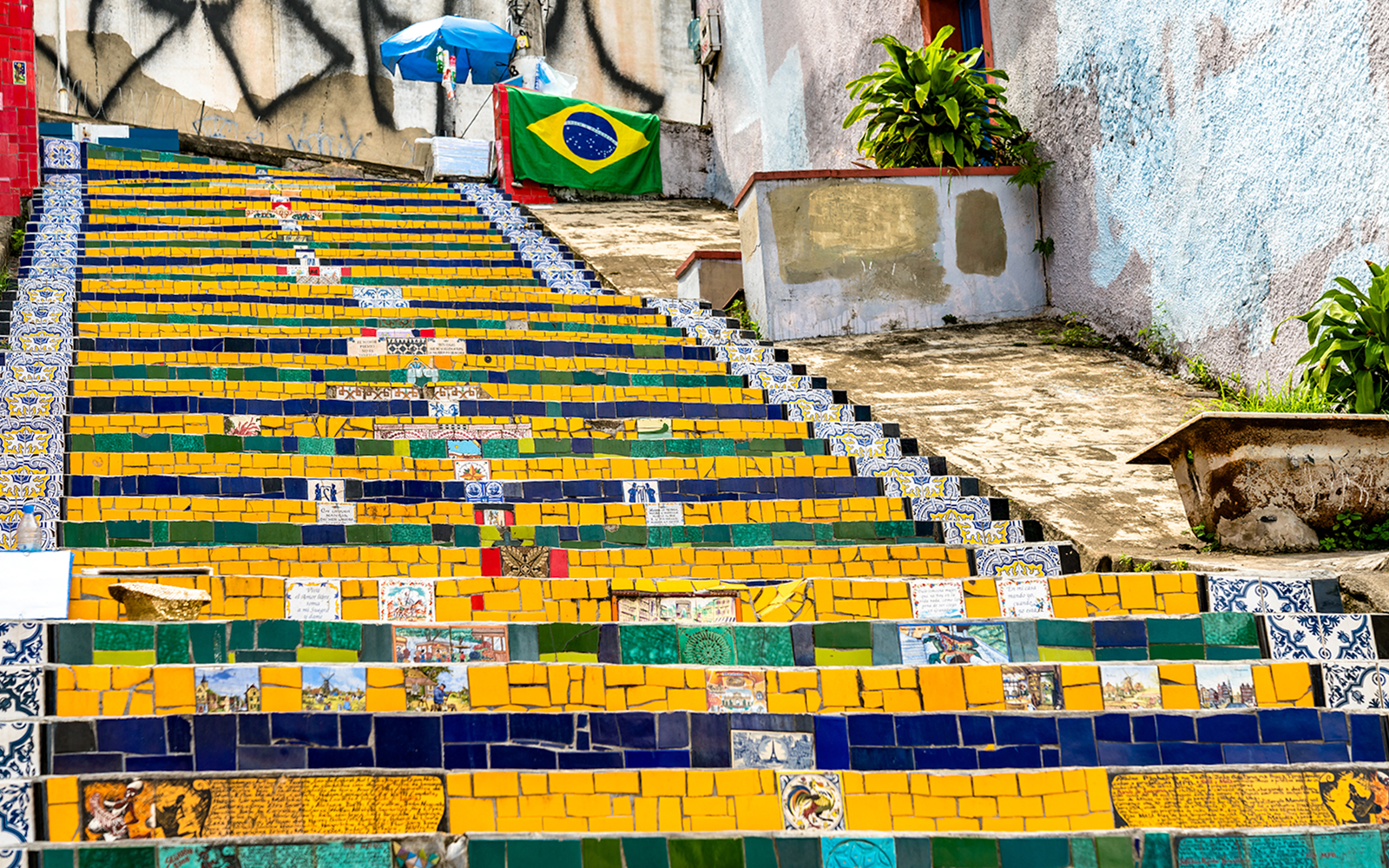 Colorful tiled Selaron Steps in Rio de Janeiro, Brazil, with Brazilian flag in background.