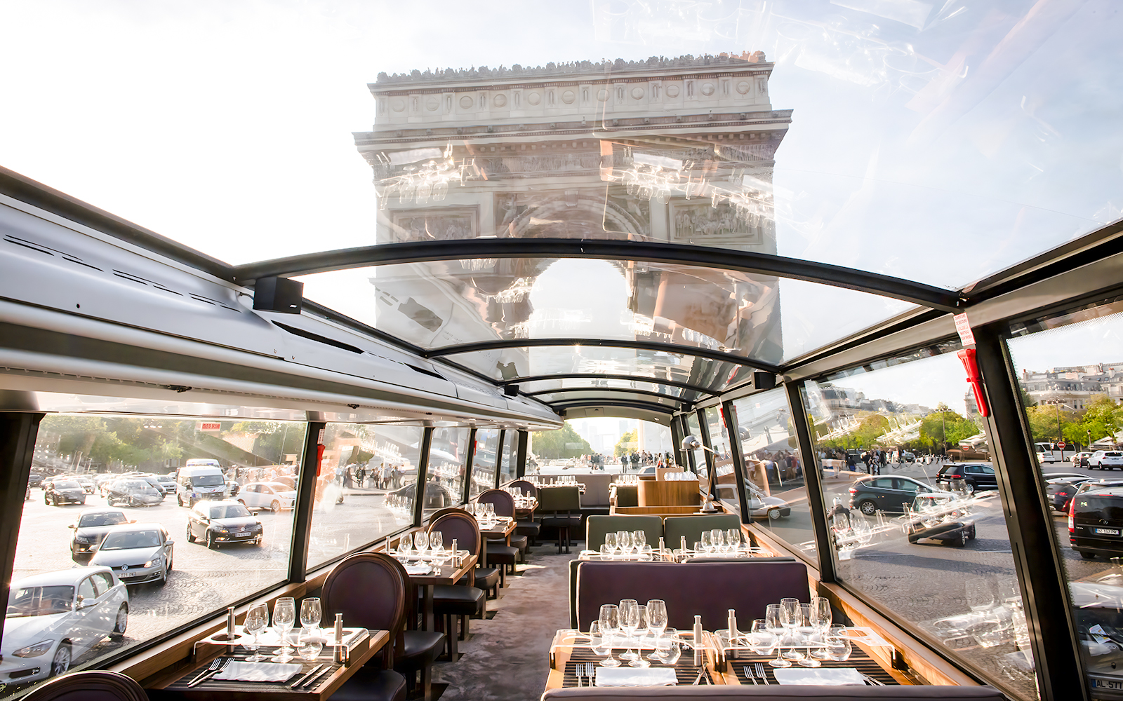 Bustronome Paris interior with dining setup and view of Arc De Triomphe.