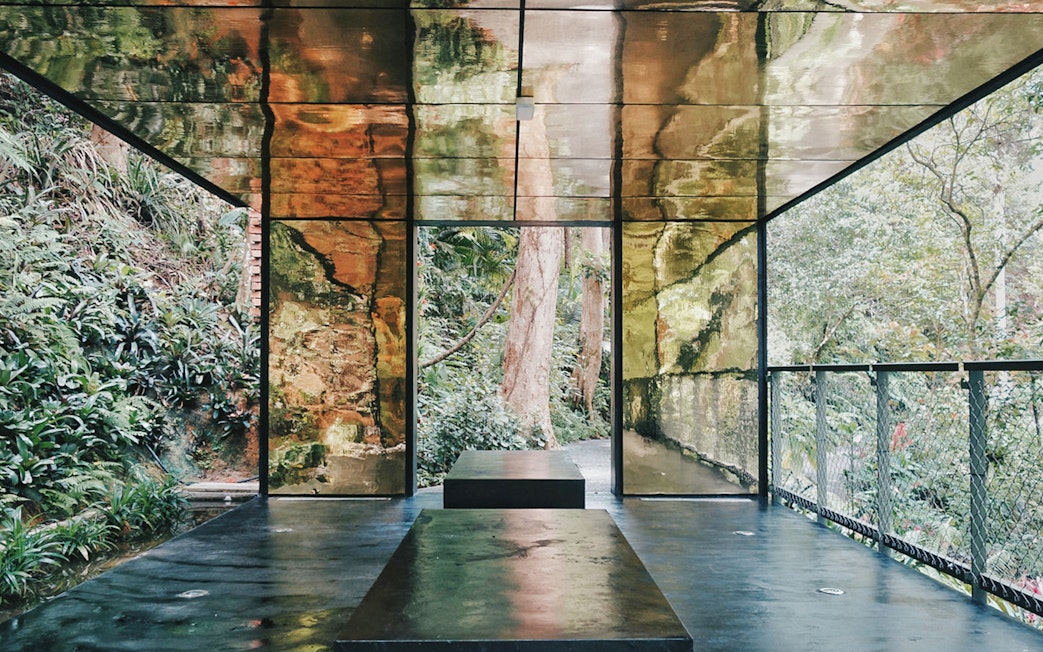 Viewing platform with reflective walls surrounded by lush greenery at Habitat Penang Hill.