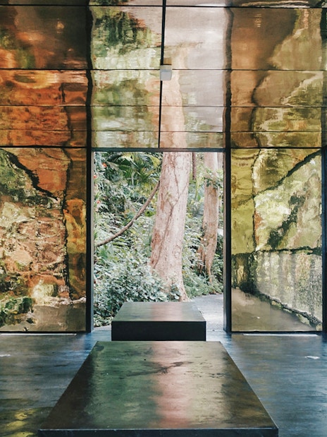 Viewing platform with reflective walls surrounded by lush greenery at Habitat Penang Hill.