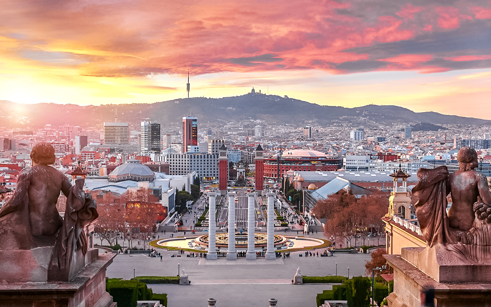 Sunset view over Barcelona from Montjuïc, highlighting cityscape and harbor.
