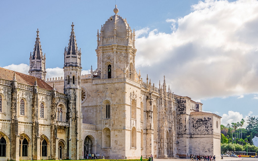 Jerónimos Monastery in Lisbon, Portugal, with ornate Gothic architecture on a sunny day.