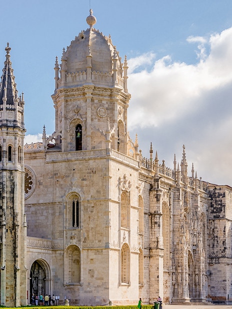 Jerónimos Monastery in Lisbon, Portugal, with ornate Gothic architecture on a sunny day.