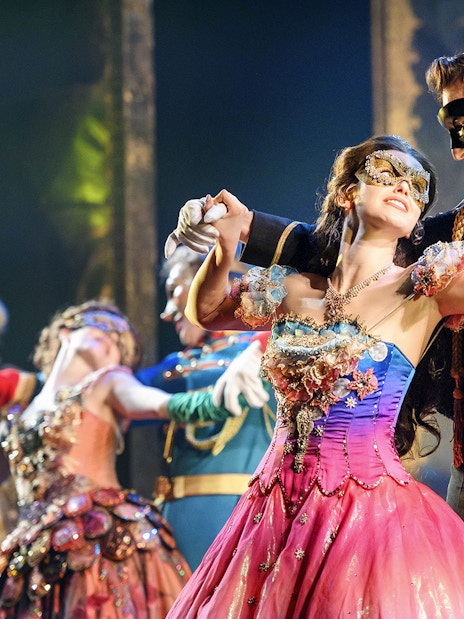 Couple in masquerade costumes dancing at The Phantom of the Opera musical in Vienna.